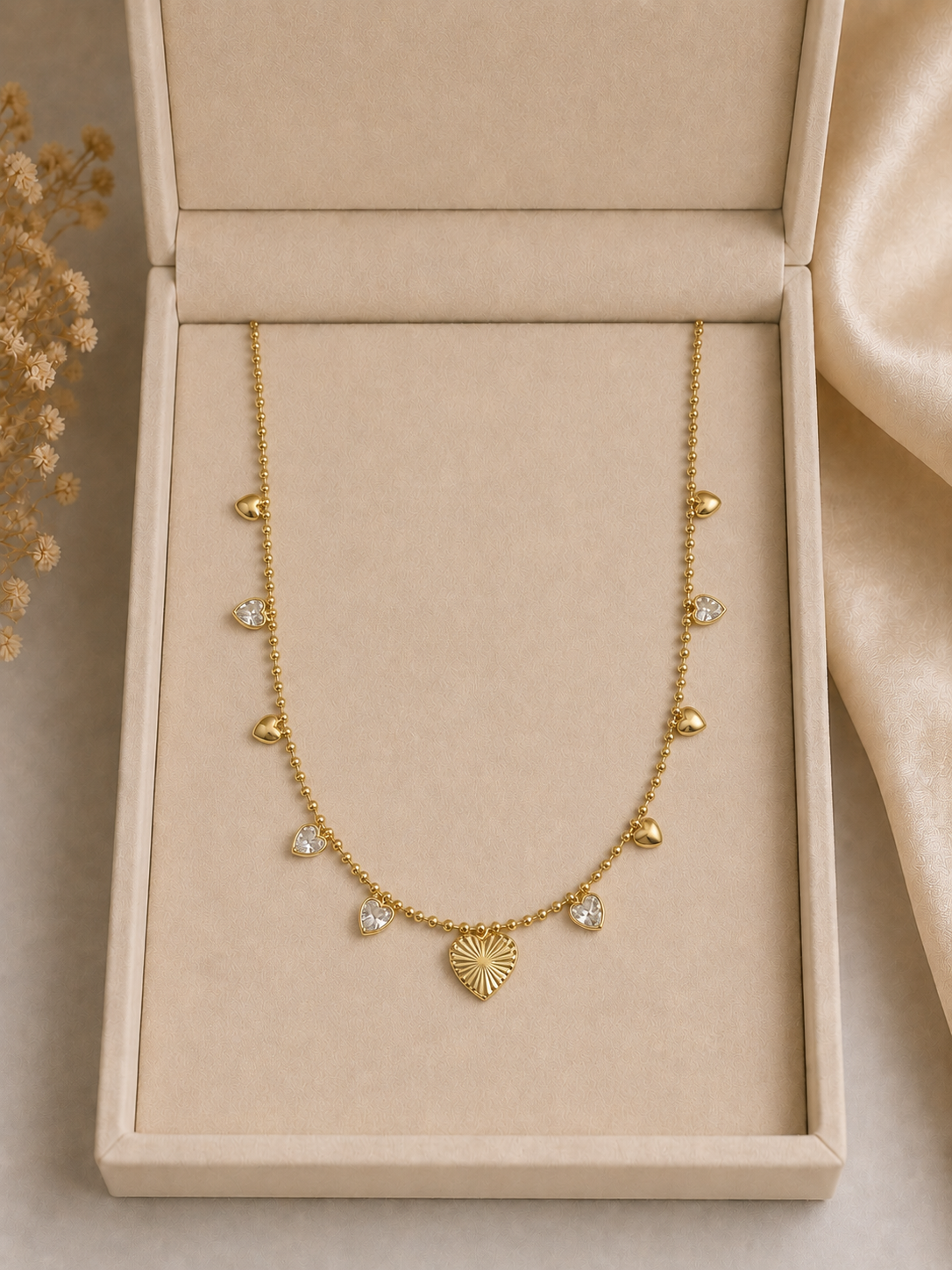 Collier breloques cœurs dorés dans un coffret beige